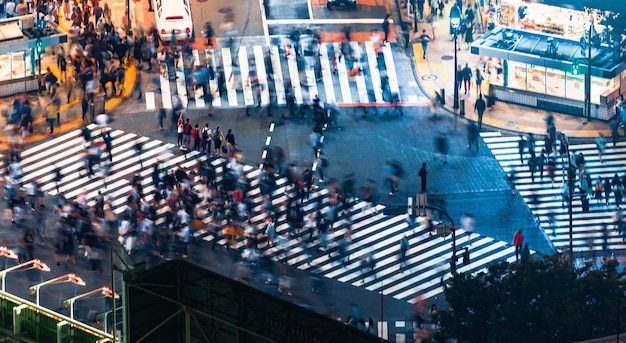 Mouvement flou des personnes traversant la route en ville