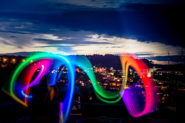 Photo mouvement flou de la roue de ferris éclairée contre le ciel la nuit