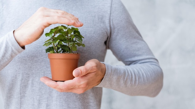 Mouvement de soins écologiques Concept de problèmes environnementaux Homme couvrant une plante d'intérieur