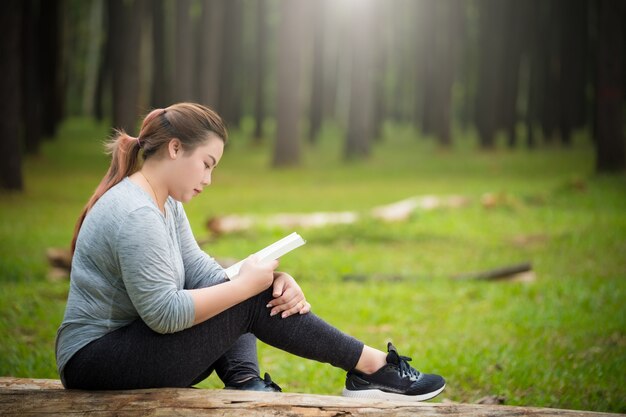 Moyen adulte femme lisant un livre au parc