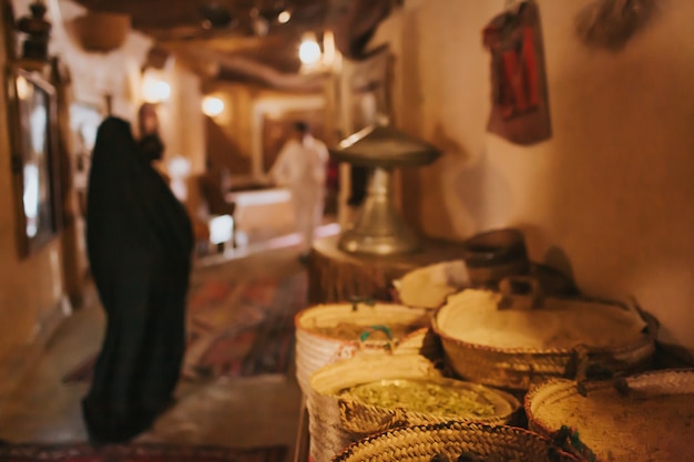 Moyen-Orient, vieux bazar. Il y a des épices sur le comptoir. Femme floue en burqa noire et abaya en arrière-plan.