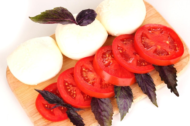 Mozzarella savoureuse aux tomates sur planche à découper isolated on white