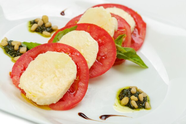 Mozzarella à la tomate et basilic isolé on white