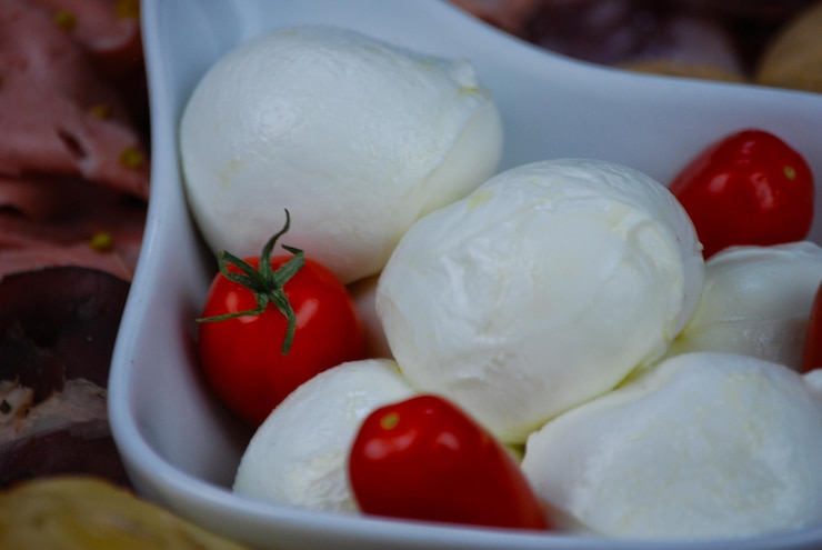 Photo mozzarella et tomates au premier plan sur un lit de fusée
