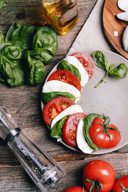 Mozzarella avec des tranches de tomates et des feuilles de basilic frais sur la table