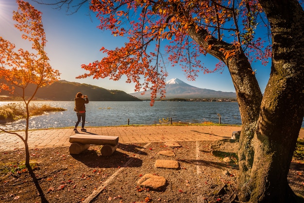 Mt. Fuji sur le lac Kawaguchiko avec feuillage automnal et femme voyageur au lever du soleil à Fujikawaguchiko, au Japon.