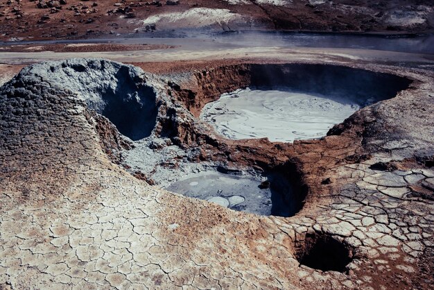 Mudpots dans la zone géothermique Hverir Islande La zone autour de la boue bouillante est multicolore et fissurée