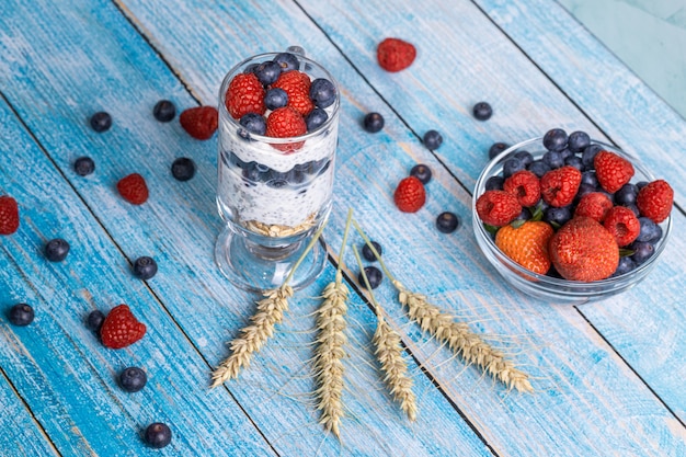 Muesli aux fruits rouges et graines de chia sur une table en bois