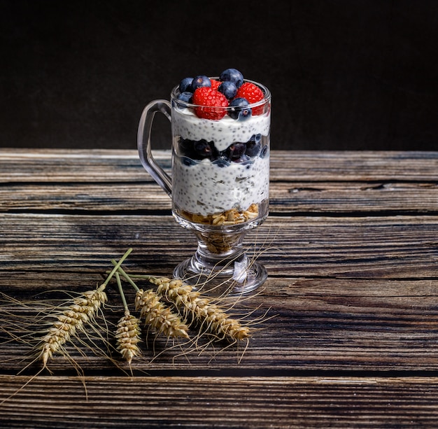 Muesli aux fruits rouges et graines de chia sur une table en bois