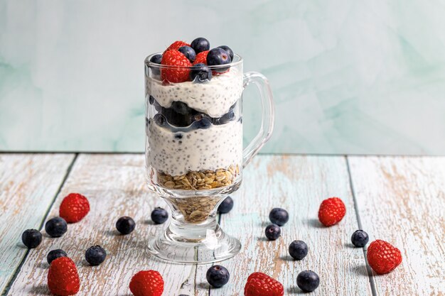 Muesli aux fruits rouges et graines de chia sur une table en bois