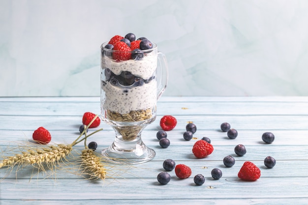 Muesli aux fruits rouges et graines de chia sur une table en bois