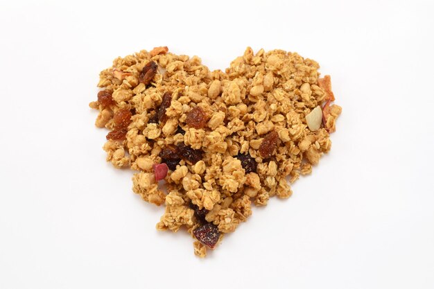 Muesli aux fruits secs disposés en forme de coeur isolé sur fond blanc