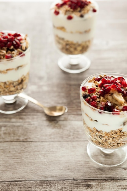 Muesli sain avec flocons d'avoine, yaourt et grenade sur fond de bois