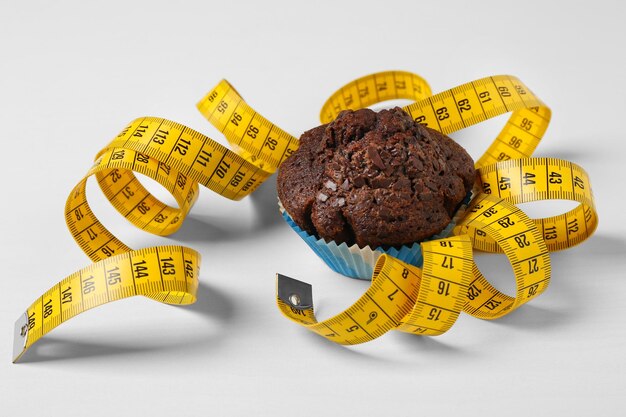 Muffin au chocolat avec centimètre sur fond blanc