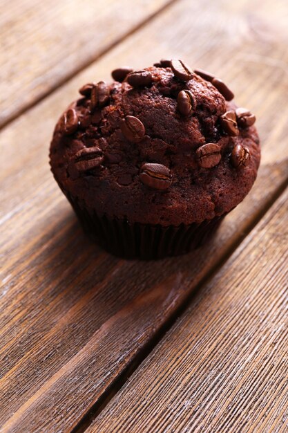 Muffin au chocolat et grains de café sur fond de bois