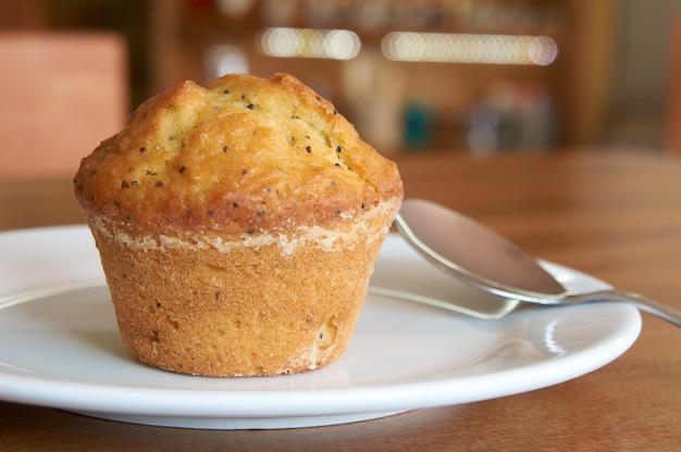 Un muffin avec une cuillère sur une plaque blanche