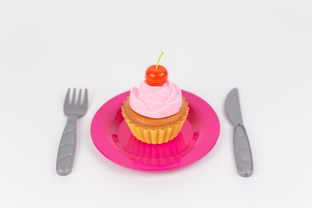 Muffin Cupcake sur une plaque sur un fond blanc avec un couteau et une fourchette