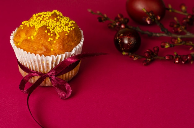 Muffin de Pâques décoré avec ruban et pépites, oeufs colorés