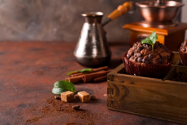 Muffins au chocolat sur une boîte en bois avec des grains de café et d&#39;épices,