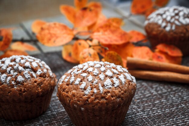 Muffins au chocolat fourrés aux pommes sur fond de feuilles d'automne et de cannelle