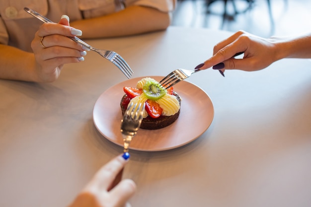 Muffins au chocolat avec fraises et crème blanche sur table en bois.