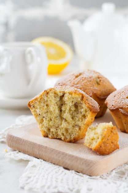 Muffins au citron aux graines de pavot sur un support en bois sur une table lumineuse. Mise au point sélective.