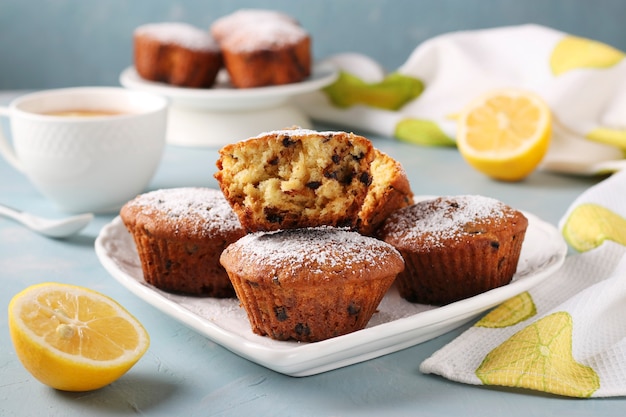 Muffins Au Citron Faits Maison Avec Du Chocolat Sur Une Plaque Blanche Sur Un Bleu Clair.