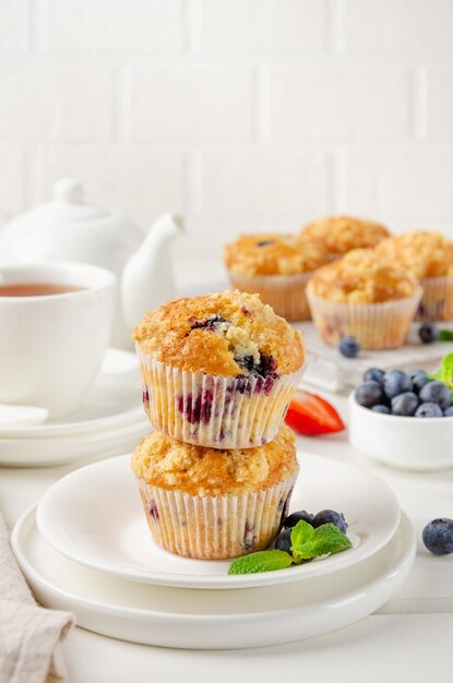 Muffins au citron avec des myrtilles et shtreisel avec des baies fraîches sur un fond en bois blanc