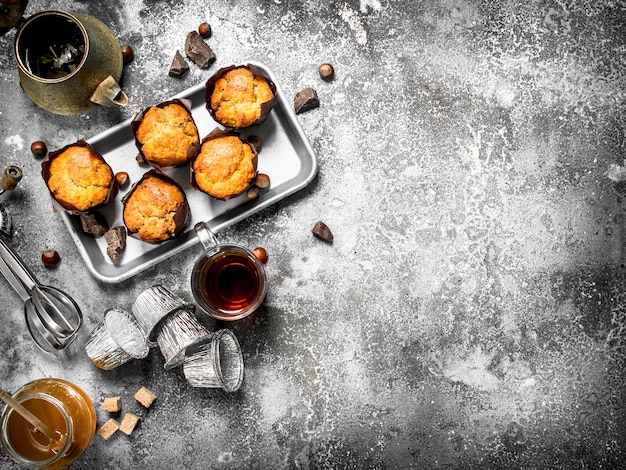 Muffins au miel avec du thé parfumé sur table rustique.