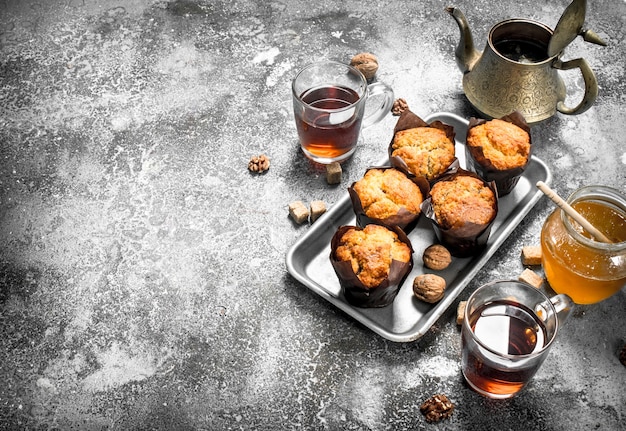 Muffins au miel avec thé parfumé. Sur une table rustique.