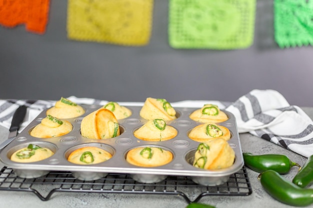 Muffins au pain de maïs fraîchement cuits avec piment jalapeno épicé dans un moule à muffins.