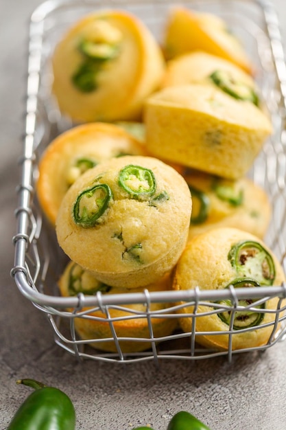 Muffins au pain de maïs fraîchement cuits avec piment jalapeno épicé dans un panier câblé.