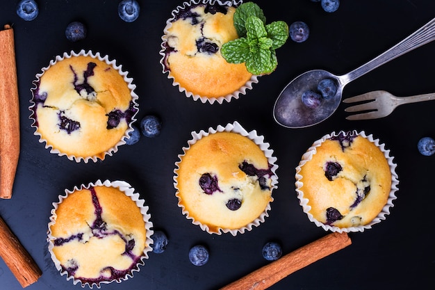 muffins aux bleuets avec du sucre en poudre et les baies fraîches