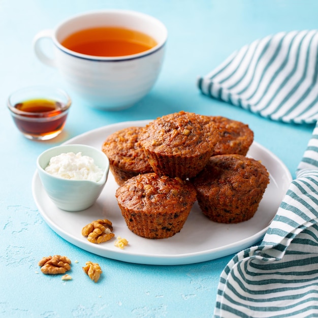 Muffins aux carottes végétaliens sains avec du fromage riccota sur une assiette fond de pierre bleue