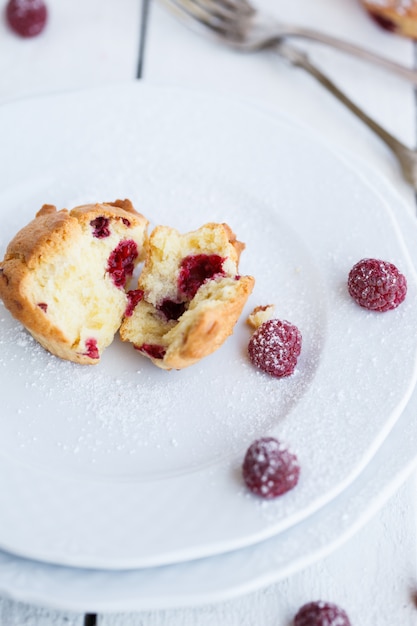 Muffins aux framboises, saupoudrés de sucre en poudre