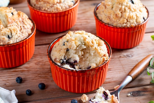 Muffins aux myrtilles cuits au four avec des myrtilles fraîches sur une table en bois avec de la menthe fraîche