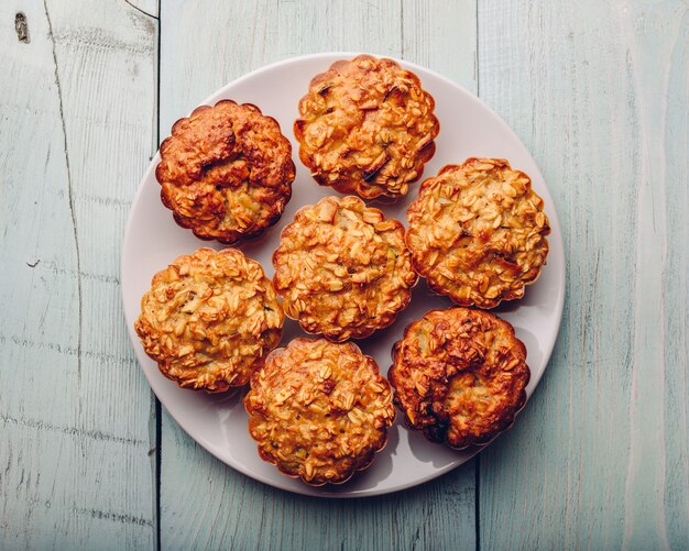 Muffins à l'avoine cuit sur plaque blanche sur table en bois clair