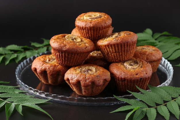 Muffins à la banane faits maison avec une tranche de banane et de cannelle sur fond sombre