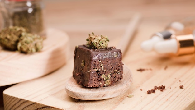 Muffins cupcake au chocolat avec des bourgeons de cannabis sur une cuillère en bois Chanvre de marijuana dans les aliments