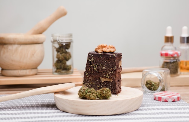 Muffins cupcake au chocolat avec bourgeons de cannabis dans une cuillère en bois pot d'huile et pots de cuisson Marijuana