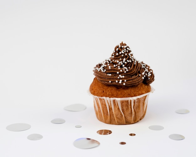 Photo muffins délicieux et confettis sur fond blanc