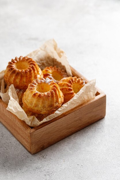 Muffins ou gâteaux à l'orange dans une boîte en bois et sur une table blanche