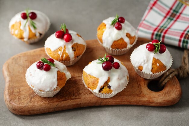 Muffins de Noël aux canneberges et au romarin servis sur planche de bois.