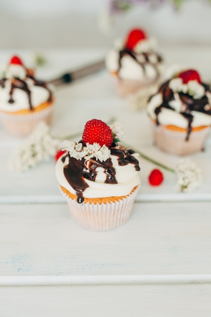 Muffins savoureux délicats décorés avec des framboises et versé