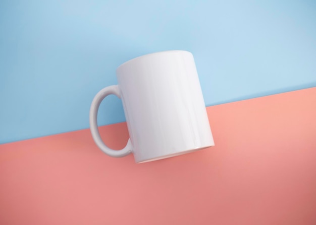 Un mug blanc sur fond rose et bleu