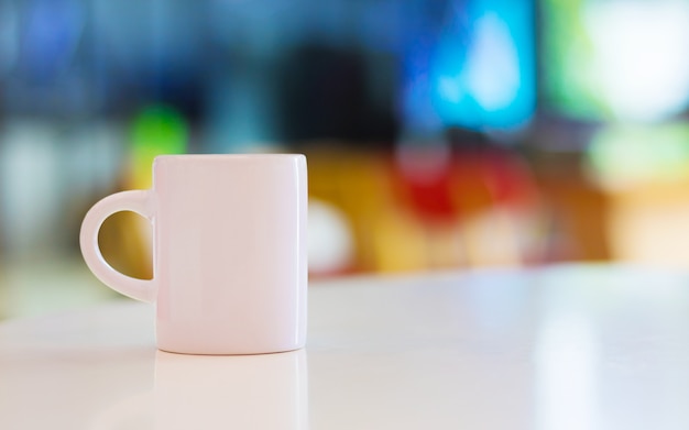 Mug blanc sur fond de tableau blanc et la surface.