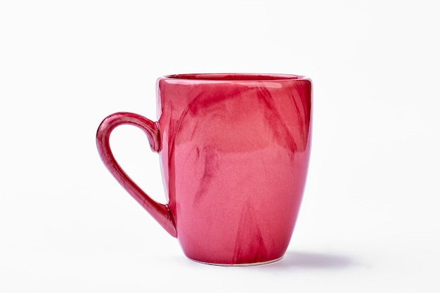 Mug en céramique sur fond blanc. Coupe rose isolée.