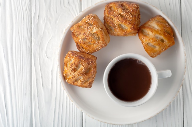 Mug avec chocolat chaud et choux sucrés sur une table en bois