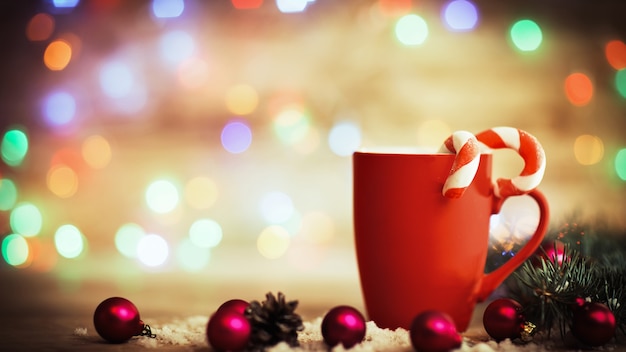 Mug de Noël avec décorations et bonbons sur fond de bois