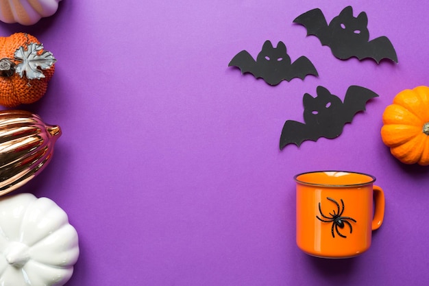 Mug orange sur fond violet avec de terribles décorations d'Halloween